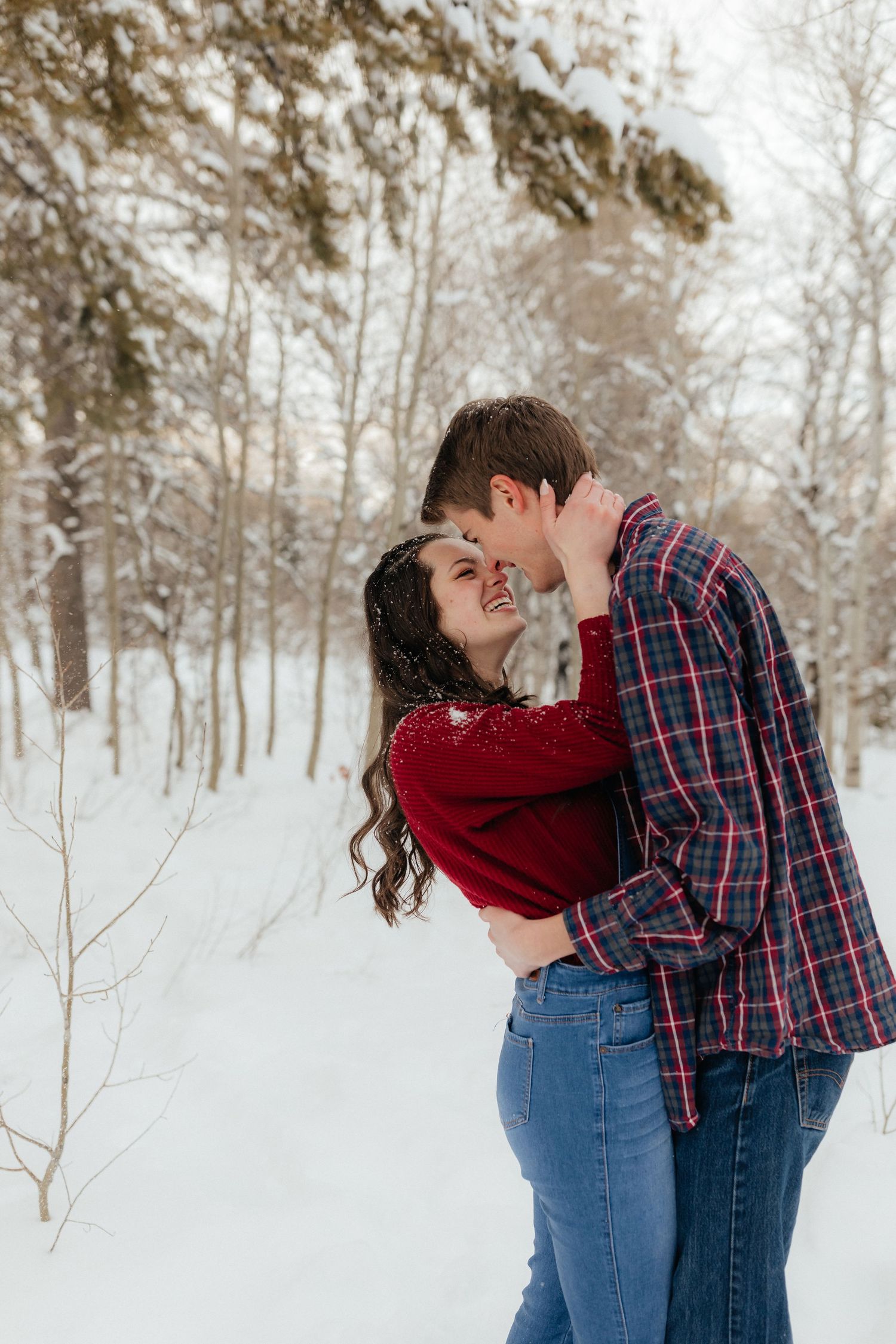 Couple Laughing and Kissing in Snowy Mountains