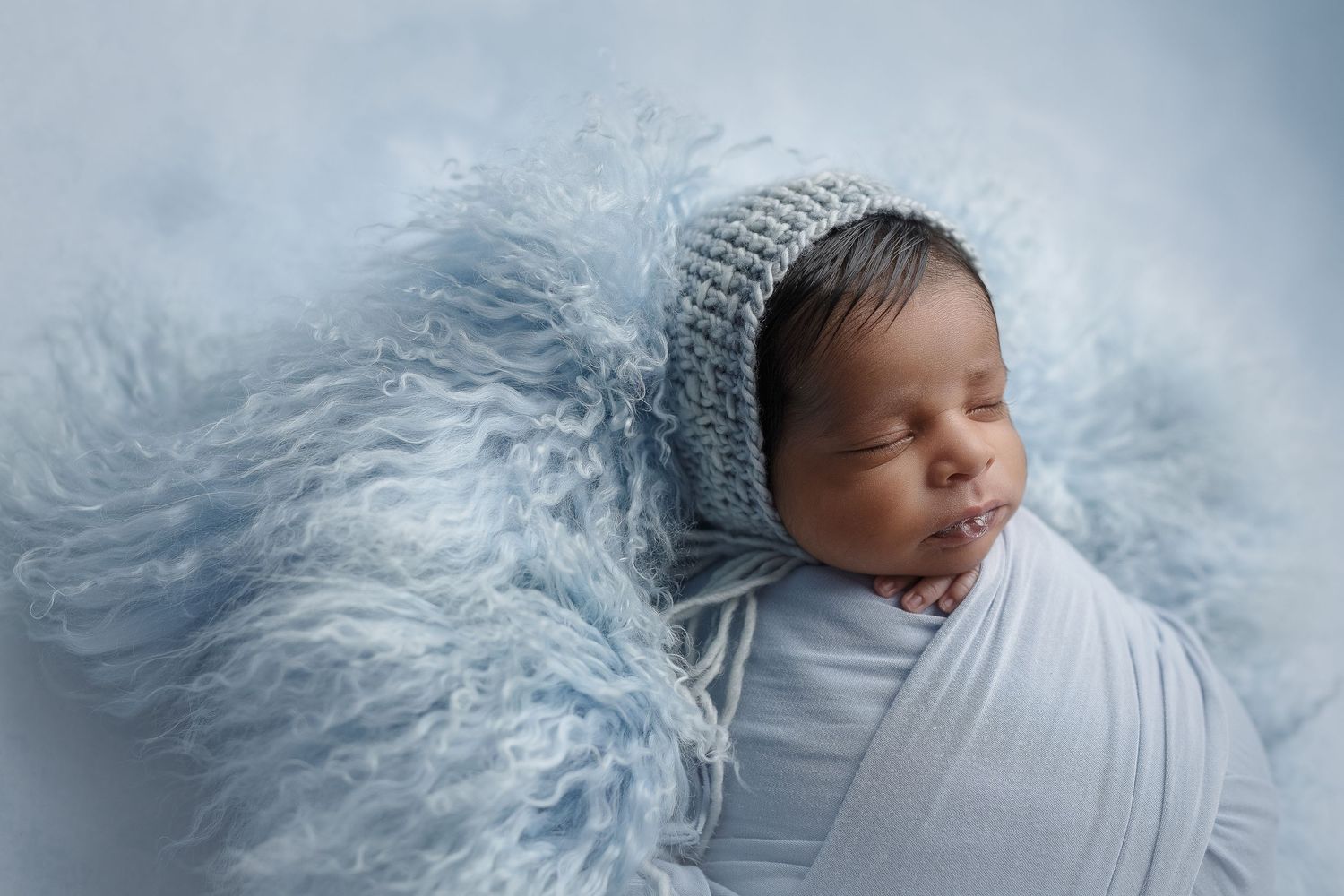 austin newborn photography newborn baby dark complexion in blue blowing bubbles