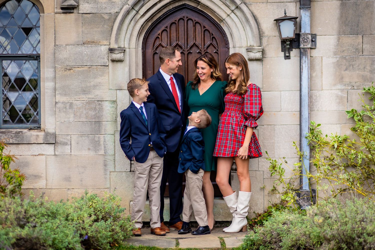 A gorgeous family dressed in holiday clothes laugh candidly