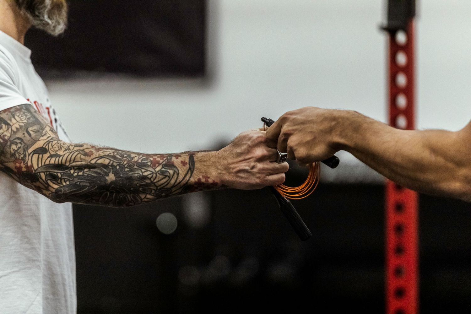 Close-up shot of two hands fist bumping, with one arm featuring intricate tattoo sleeve artwork.
