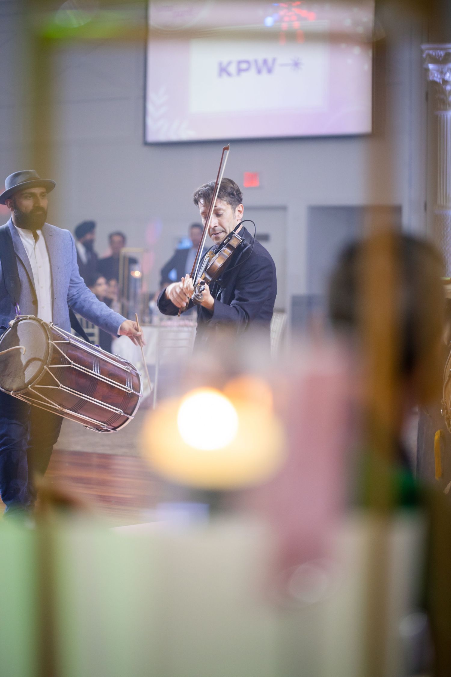 Musicians performing with traditional drums in an indoor venue setting.