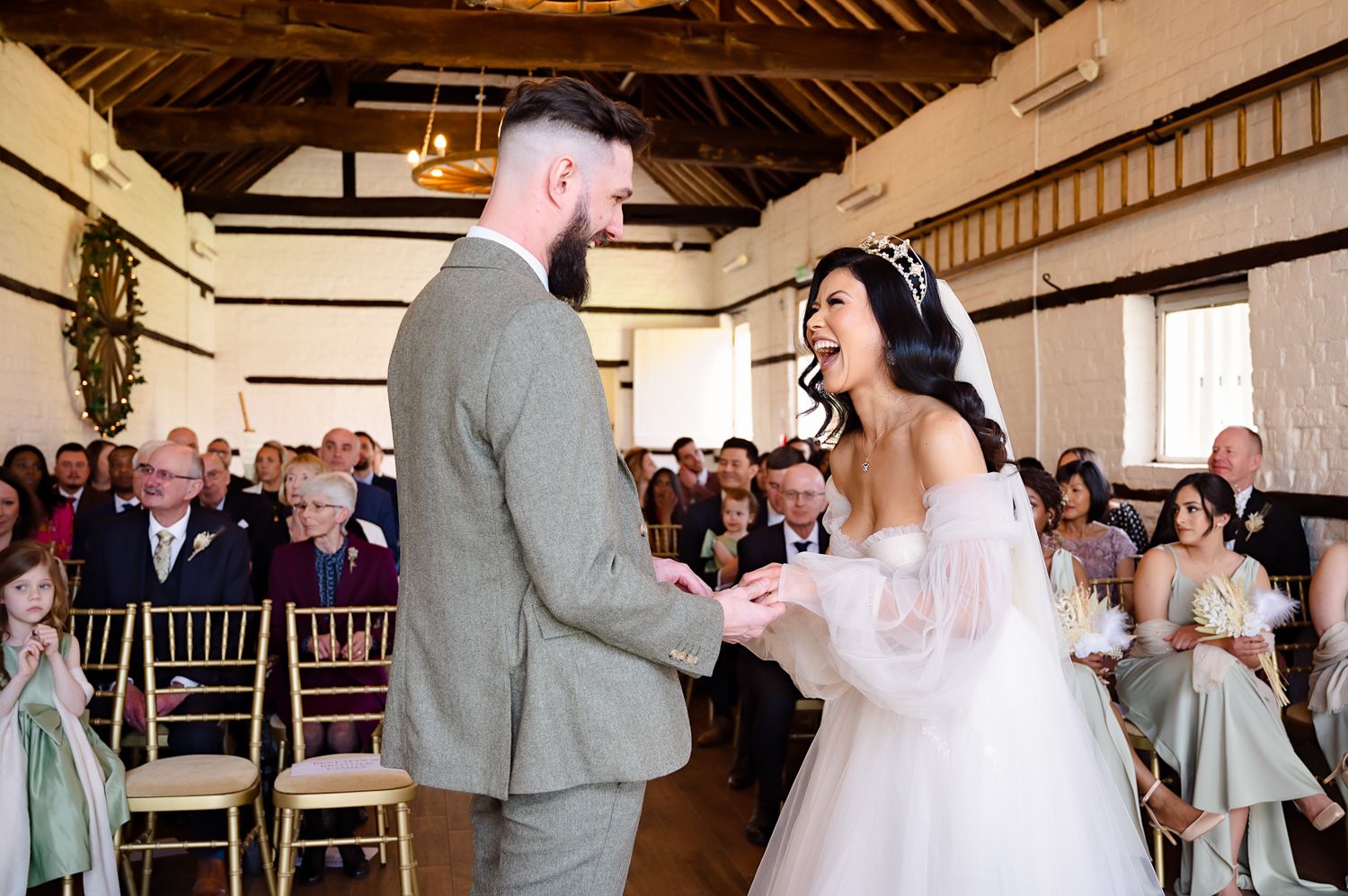 Wedding ceremony moment with couple exchanging vows in front of seated guests.