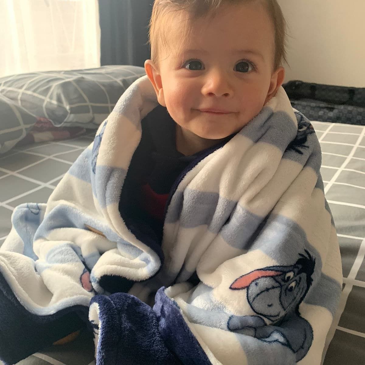 Baby wearing cozy white fleece with blue accents.