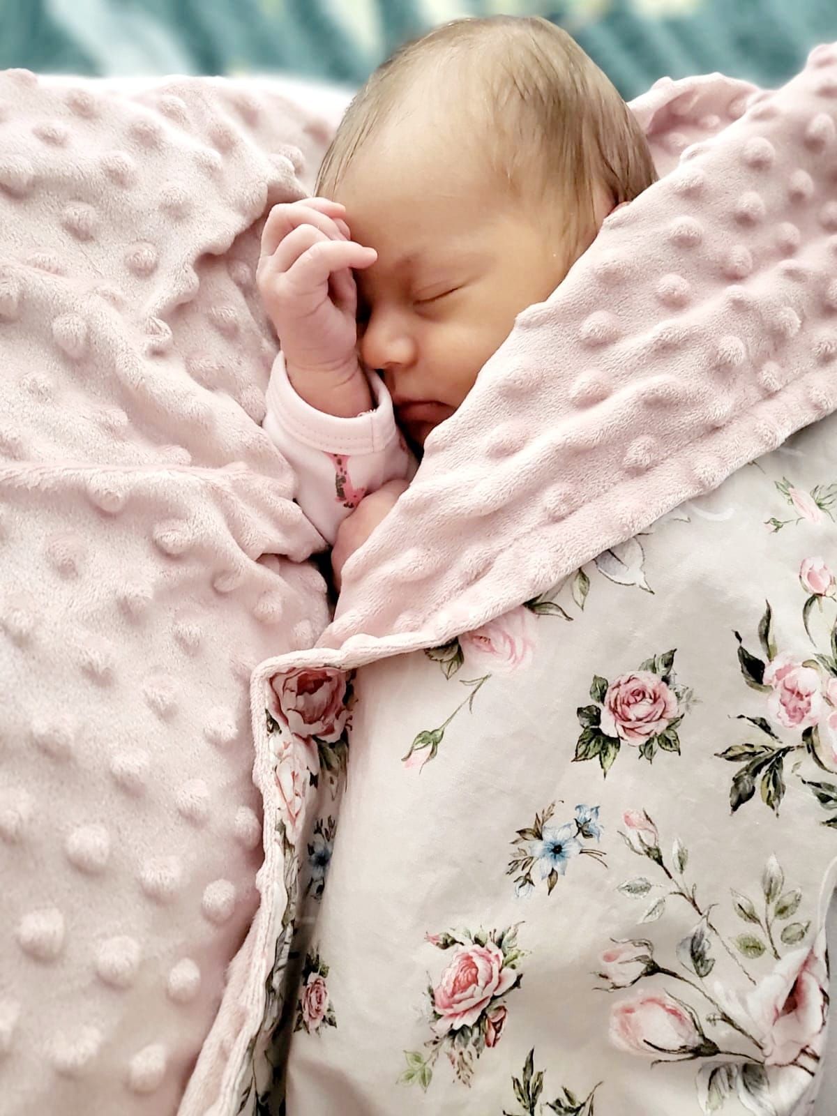 Pink minky blanket with floral rose pattern and textured dotted surface.