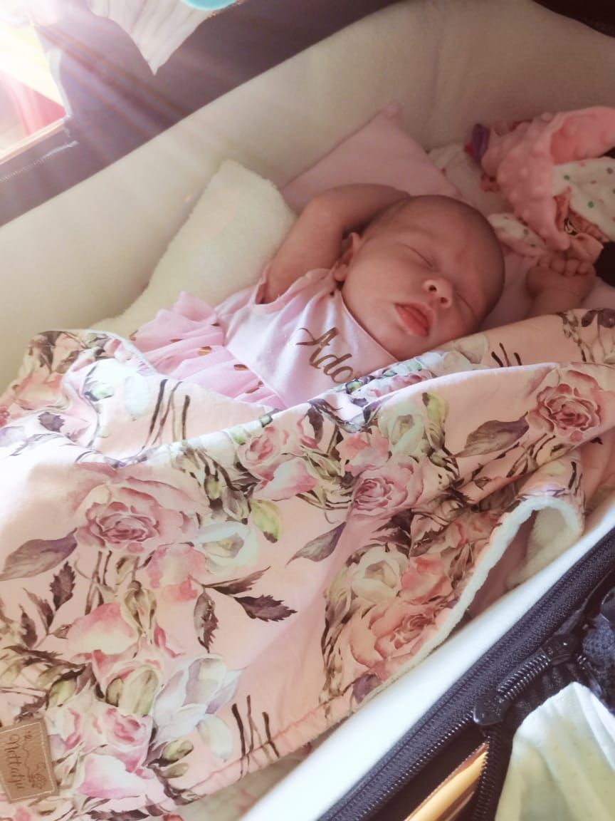 Baby sleeping on floral pink bedding in peaceful repose.