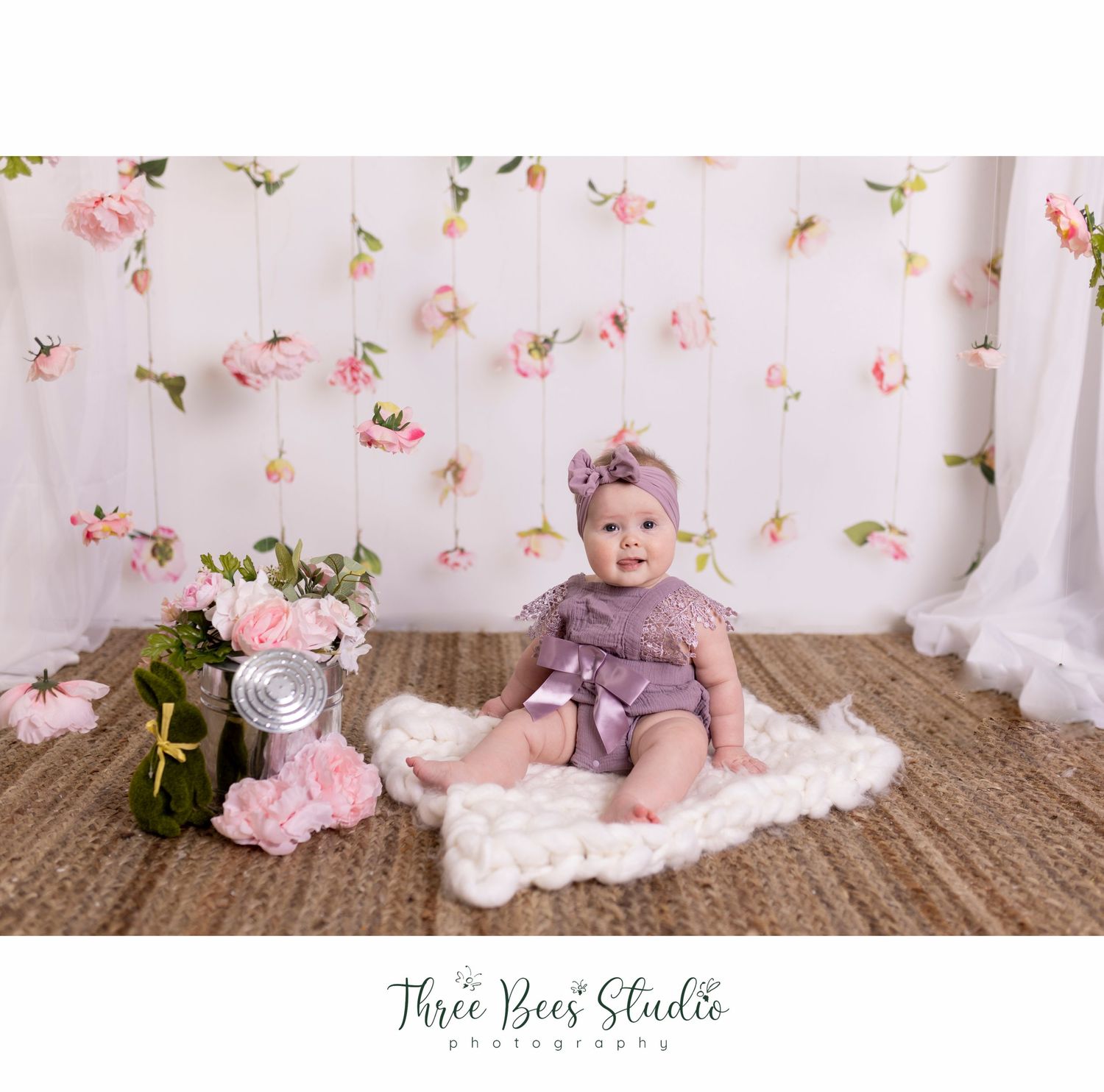 Spring studio portrait with floral backdrop, bunny decor, and soft pink roses.