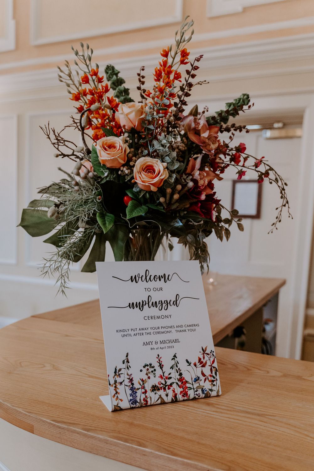 an unplugged wedding ceremony sign and a bouquet of flowers