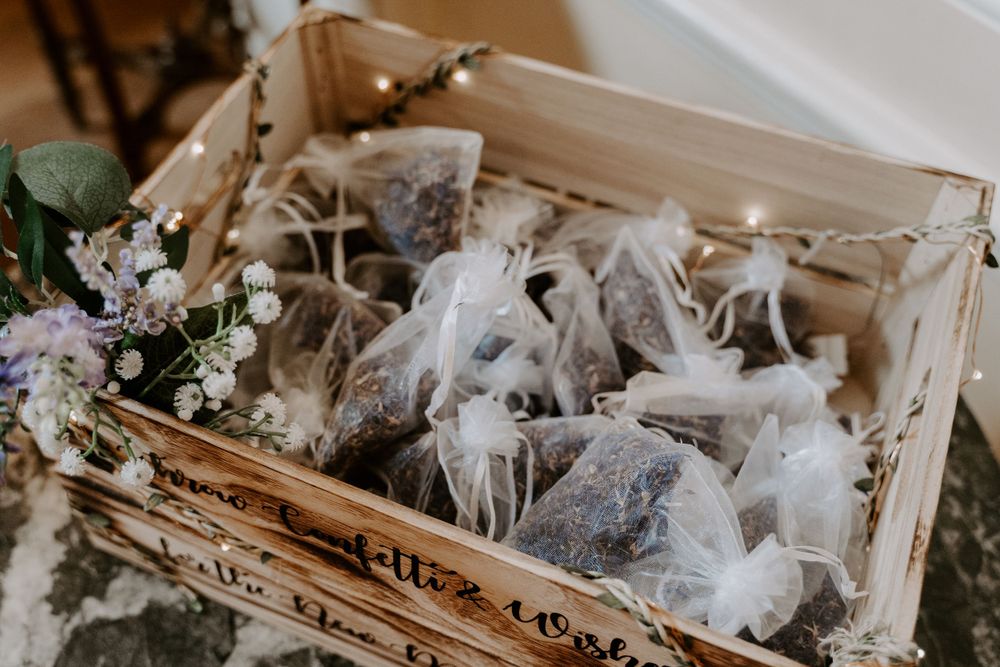 a wooden crate filled with organza bags of flower petal confetti.
