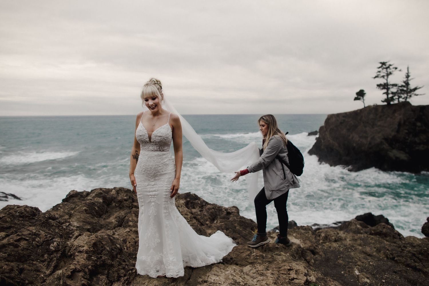 Wedding portrait on dramatic coastal cliffs with crashing waves below.
