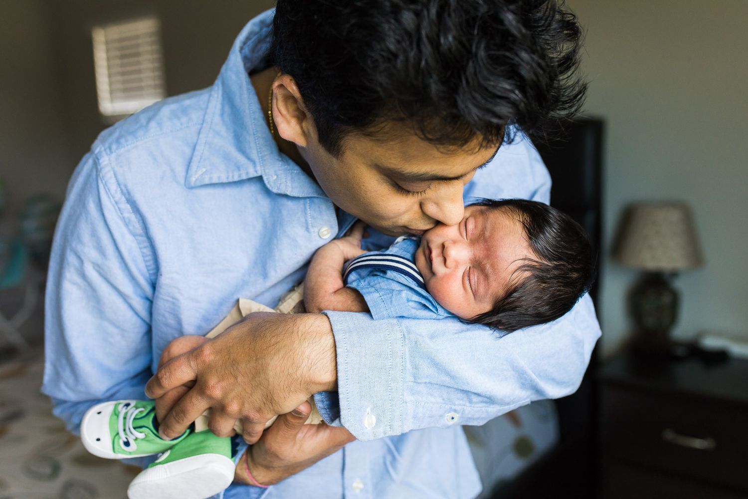 Father kissing newborn son in Seattle home.