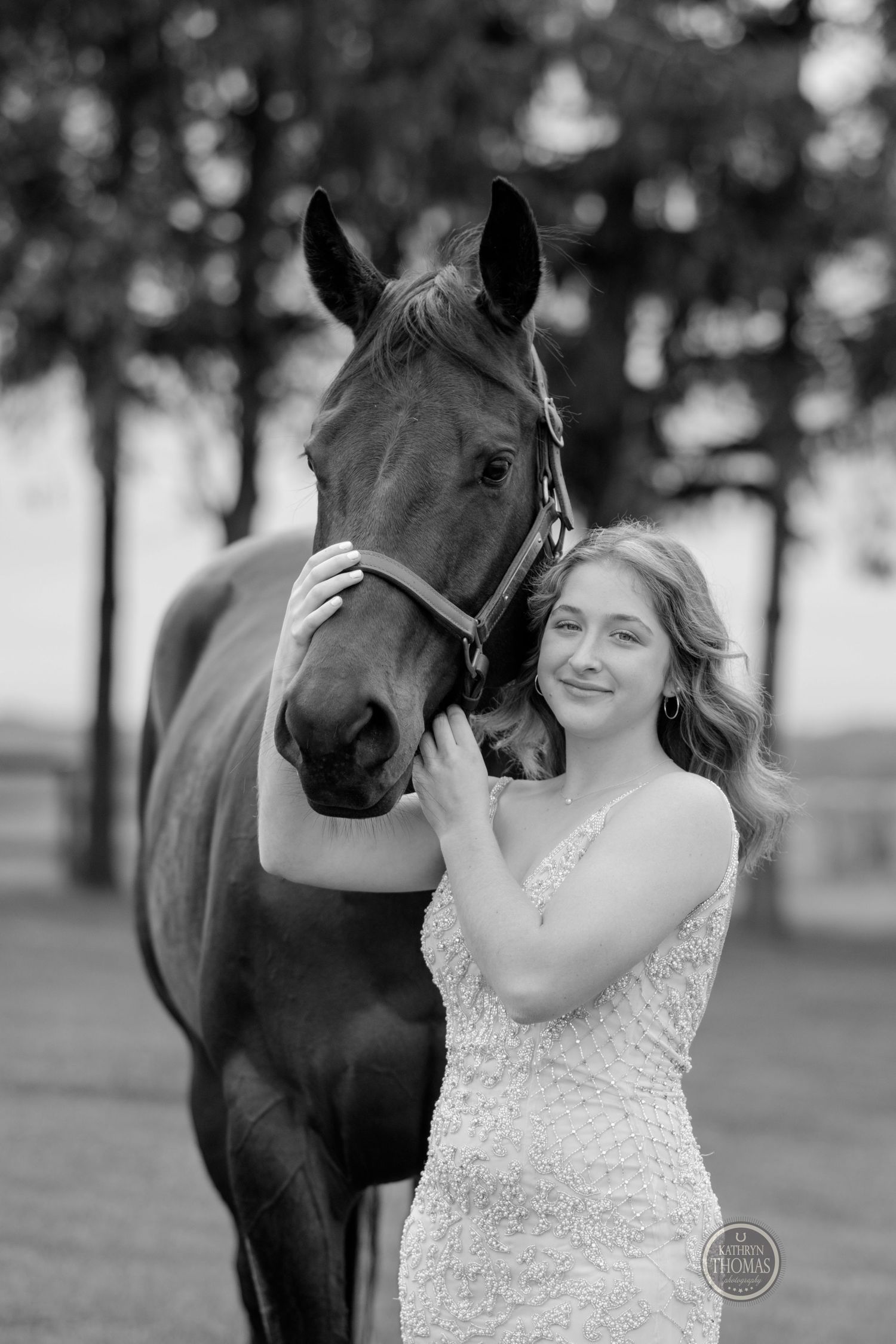 A black and white portrait showing a tender moment between a horse and someone in a lace dress.