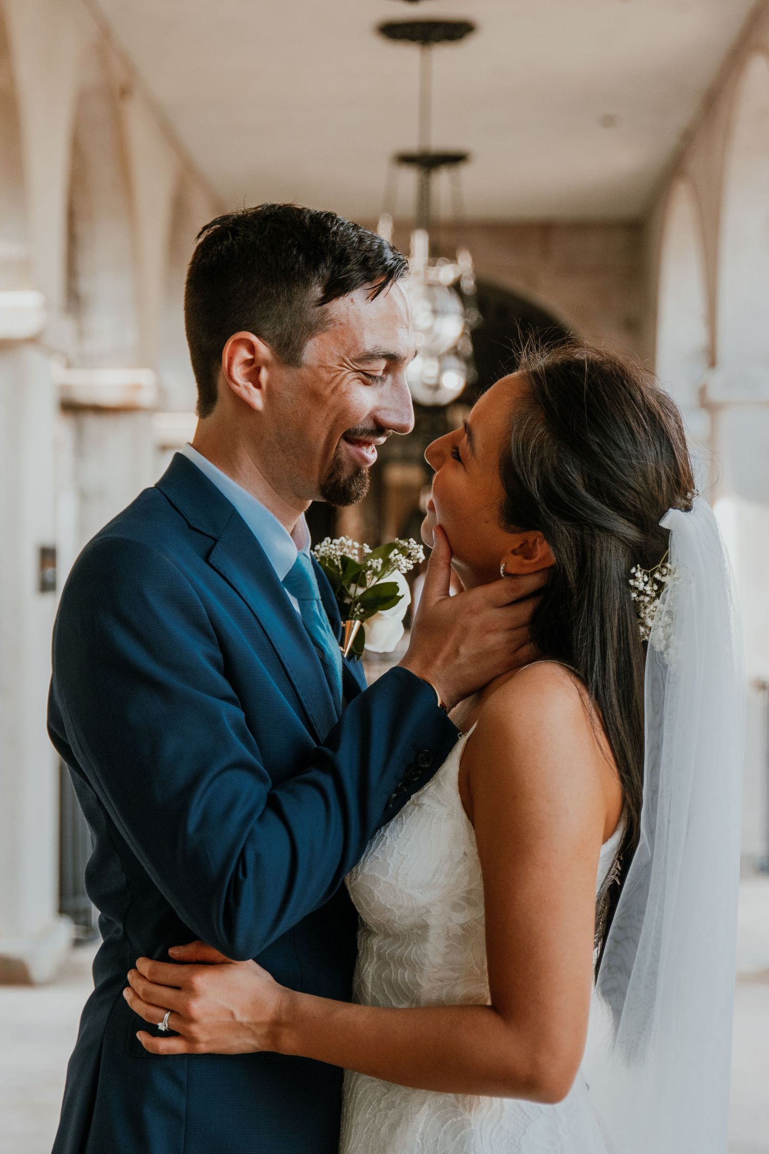 Candid wedding moments showing a couple sharing joyful laughter in an indoor venue.