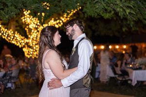 bride and groom during first dance with tree with lights around it behind them in Orland, California Wedding