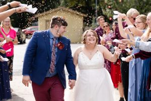 Bride and groom during exit with dried flowers falling on them. They look excited Chico, California Wedding