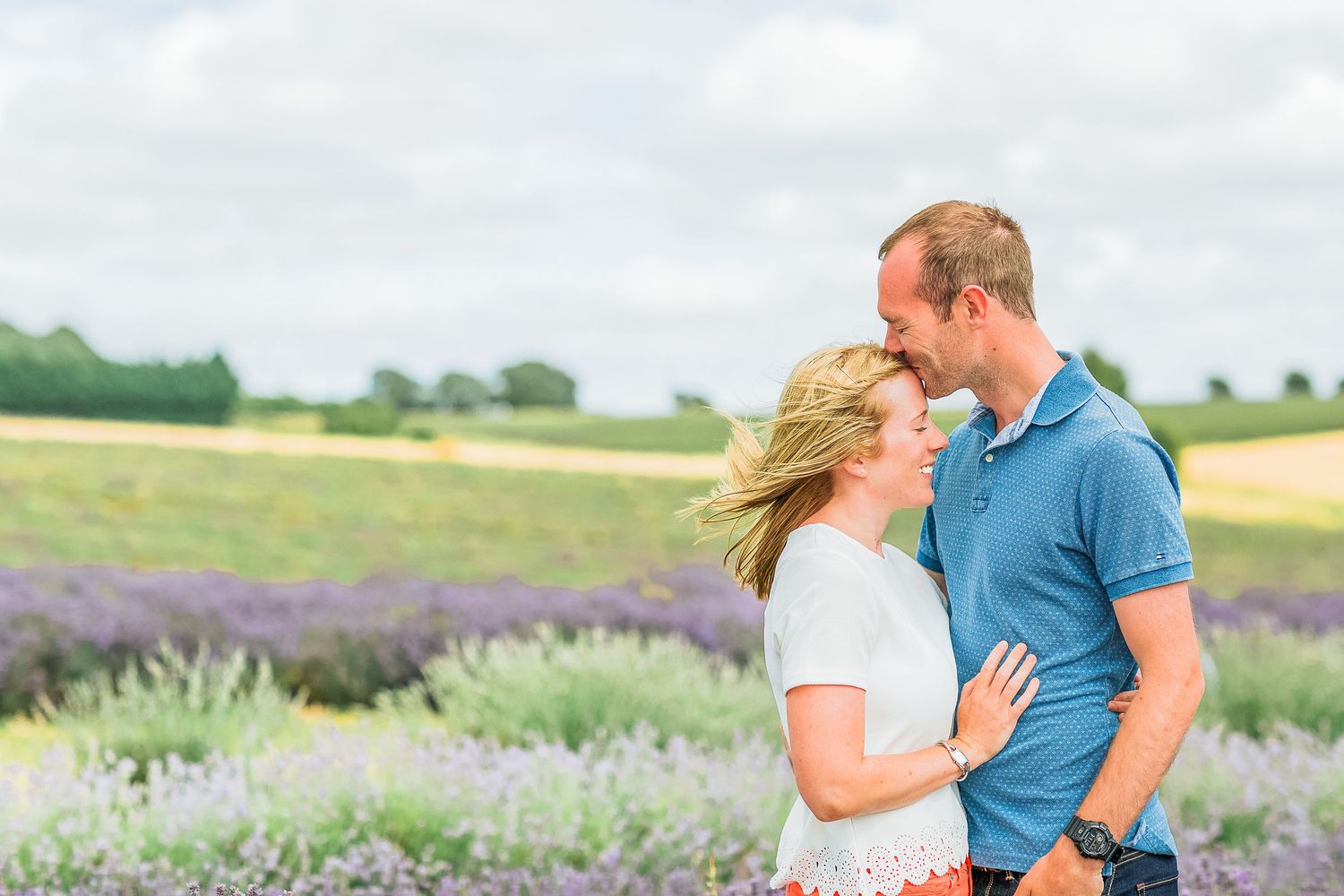 Hayley Elizabeth Photography Cotswolds Photographer Lavender engagement session Snowshill gent kisses forehead of fiance