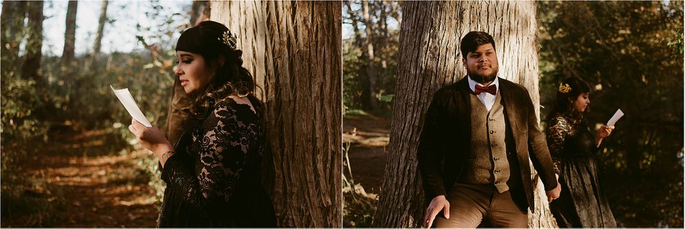 Two people in vintage attire pose dramatically between large tree trunks in a forest setting.