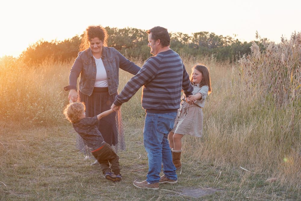 Michelle Deppe Photography with family in tall grass at tunnel springs park utah.