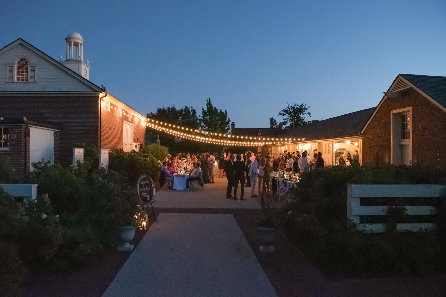 Outdoor wedding venue at dusk with string lights creating a romantic ambiance.