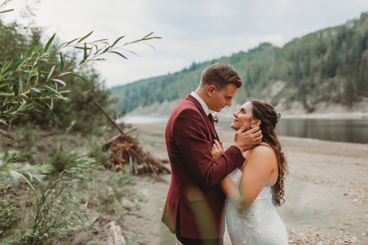 A couple on their wedding day pose near a river in Grande Prairie Alberta