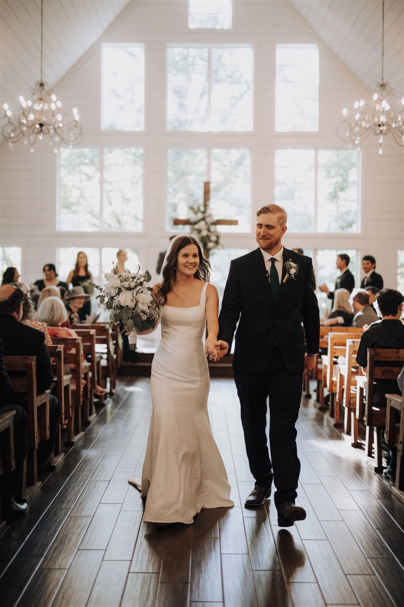 Classic church wedding ceremony with beautiful stained glass windows and elegant chandeliers.