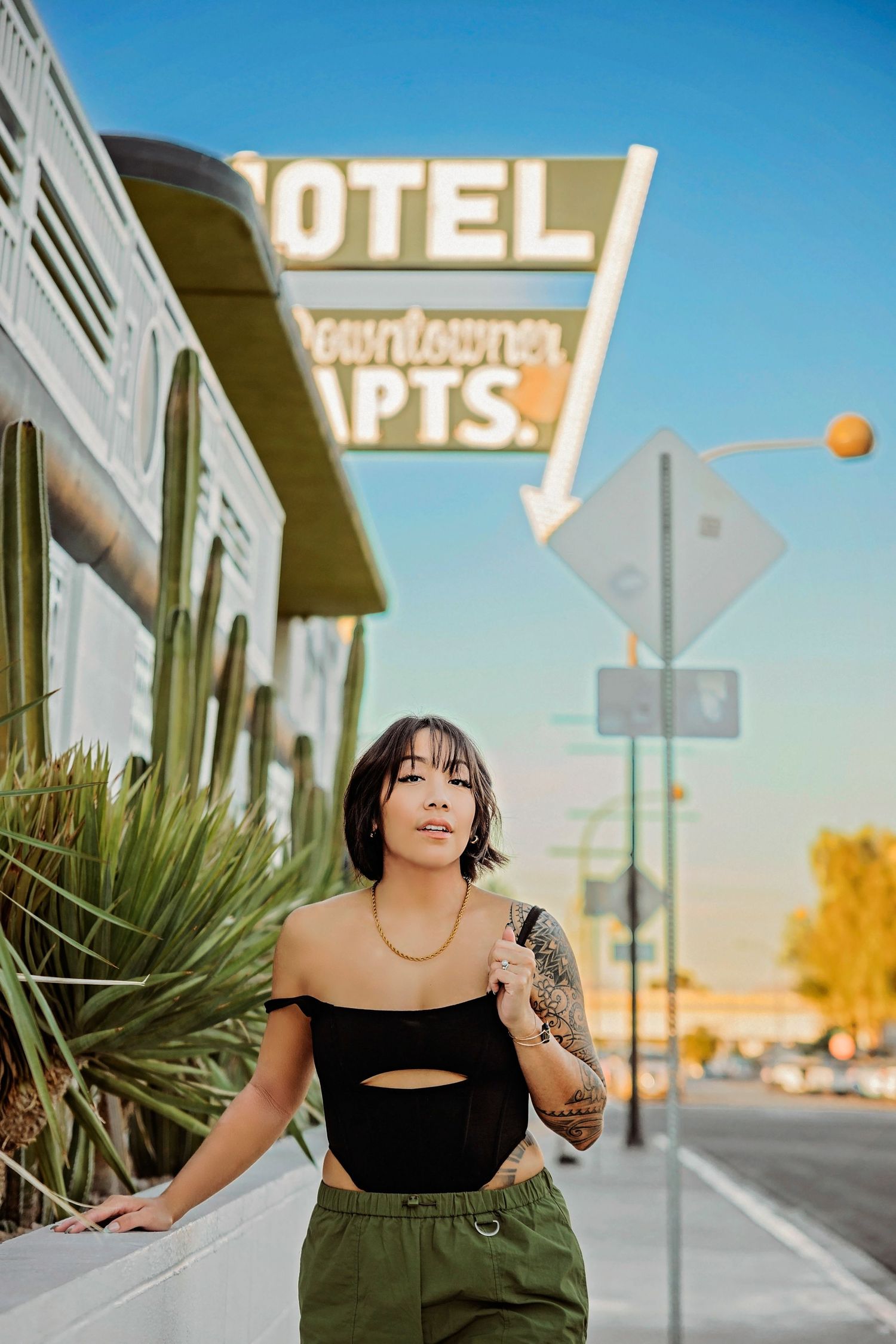 Street scene with retro motel signage and urban architecture in background.