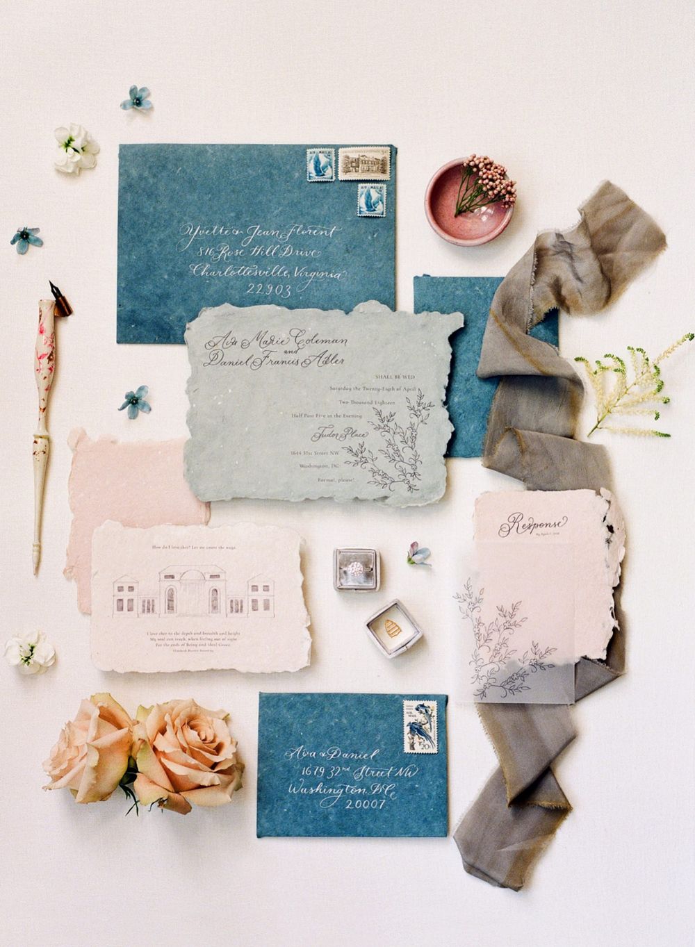 Vintage-inspired wedding invitation suite in blue and blush tones with floral accents and silk ribbon.