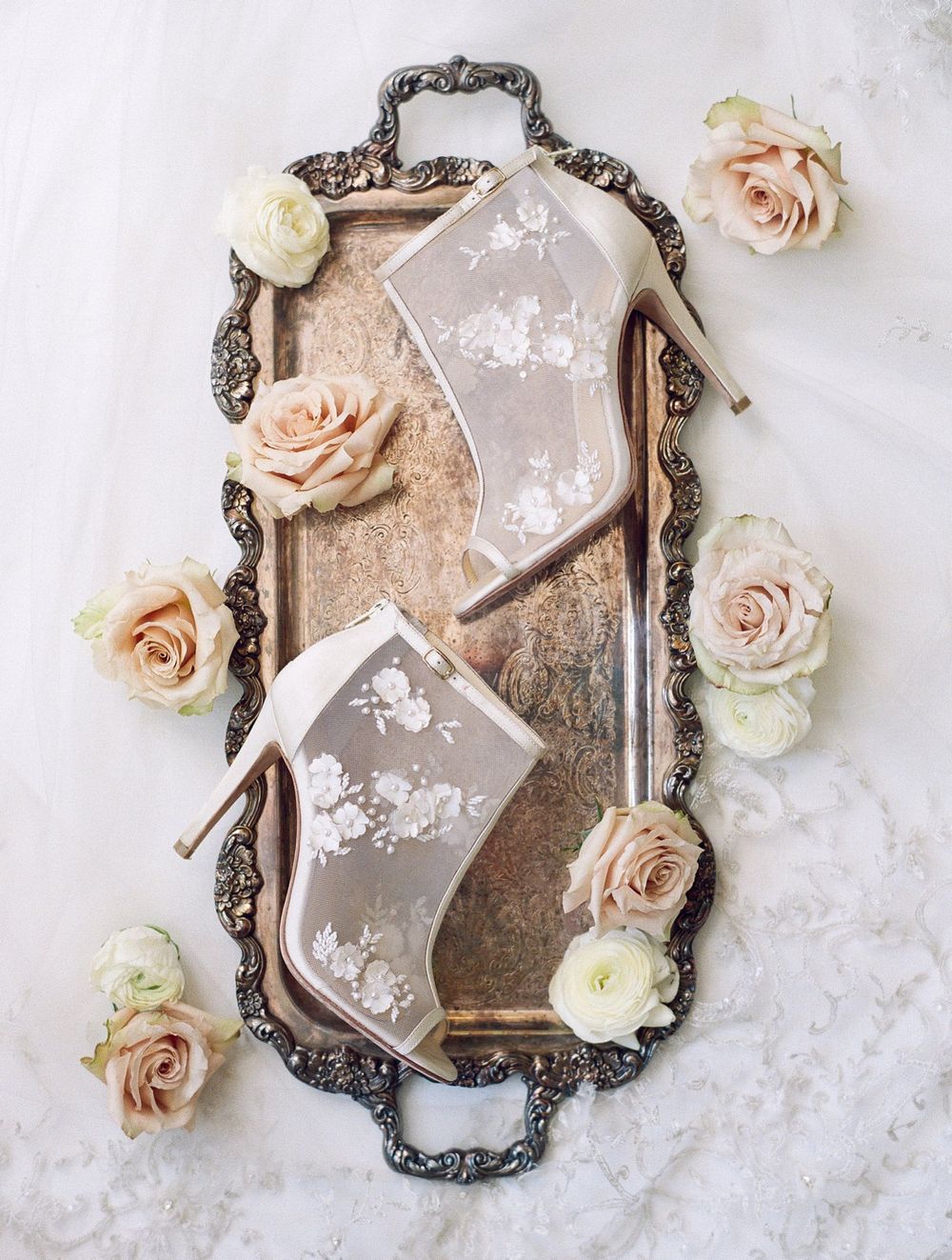 Vintage silver tray with lace wedding boots and blush pink roses as elegant styling elements.