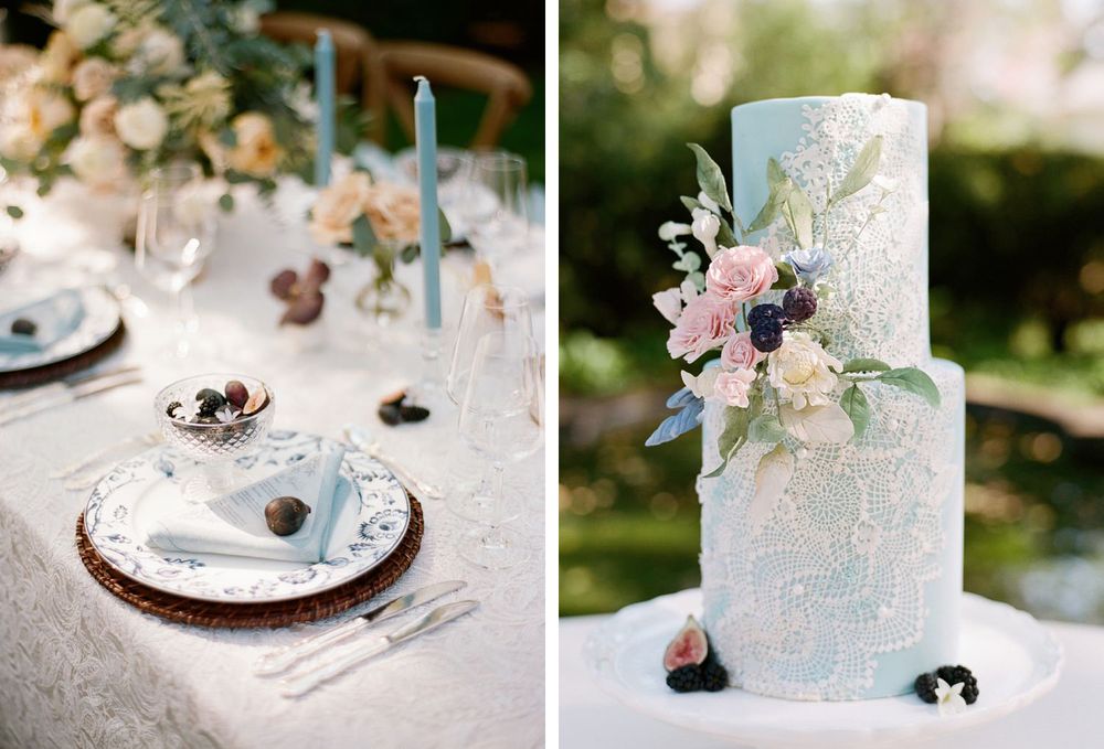 Wedding table setting with blue candles and a two-tier pale blue cake decorated with flowers.