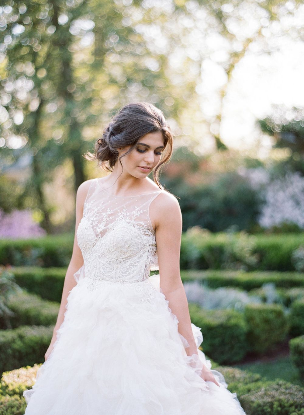 Romantic garden wedding portrait featuring a flowing white lace gown with tulle skirt.