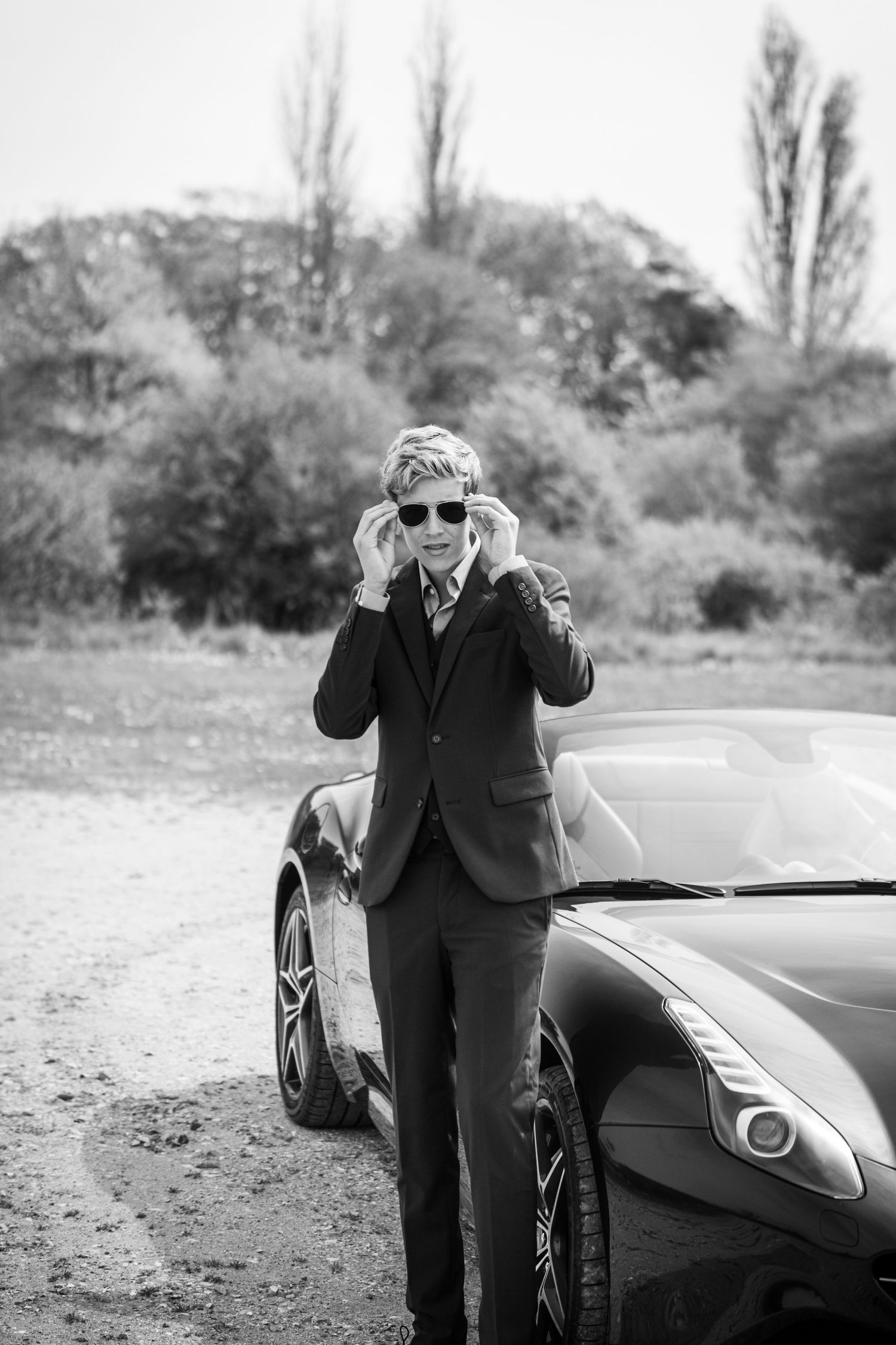Konfirmand i cool stil foran sportsvogn – portrætter med kant. Fotograf Jægerspris, Frederikssund & Nordsjælland.