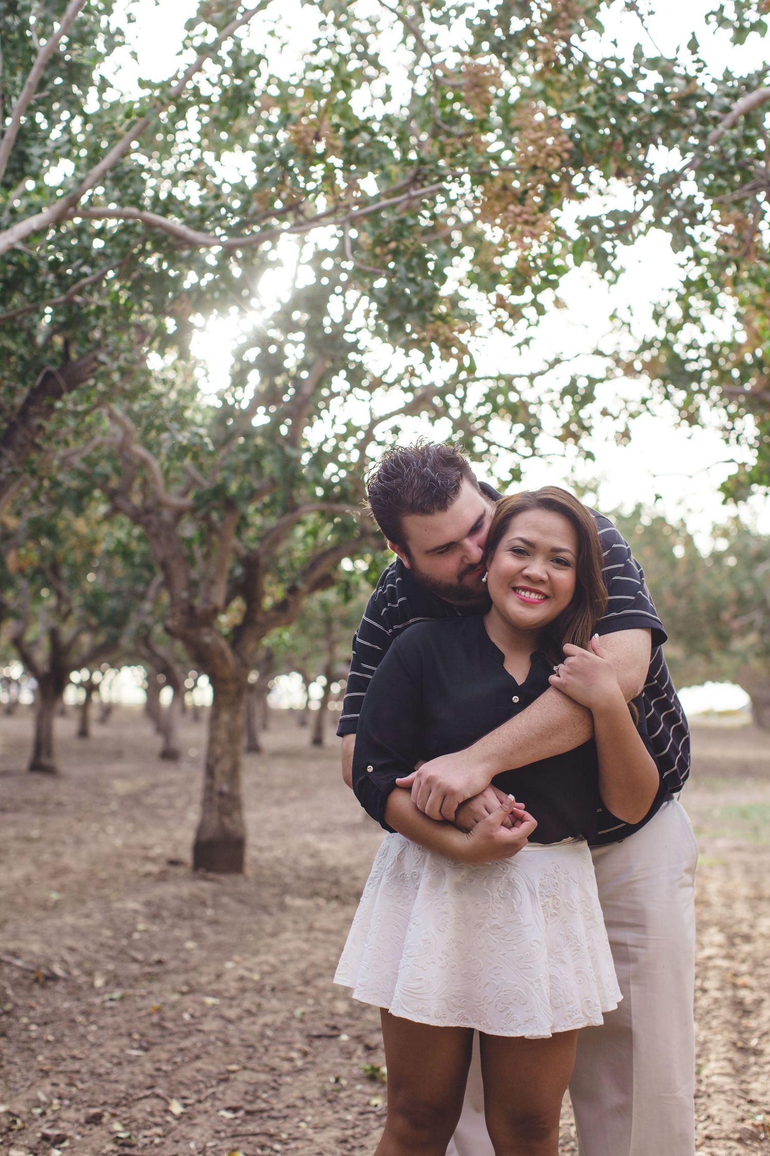 Romantic couple photos in an orchard during golden hour.