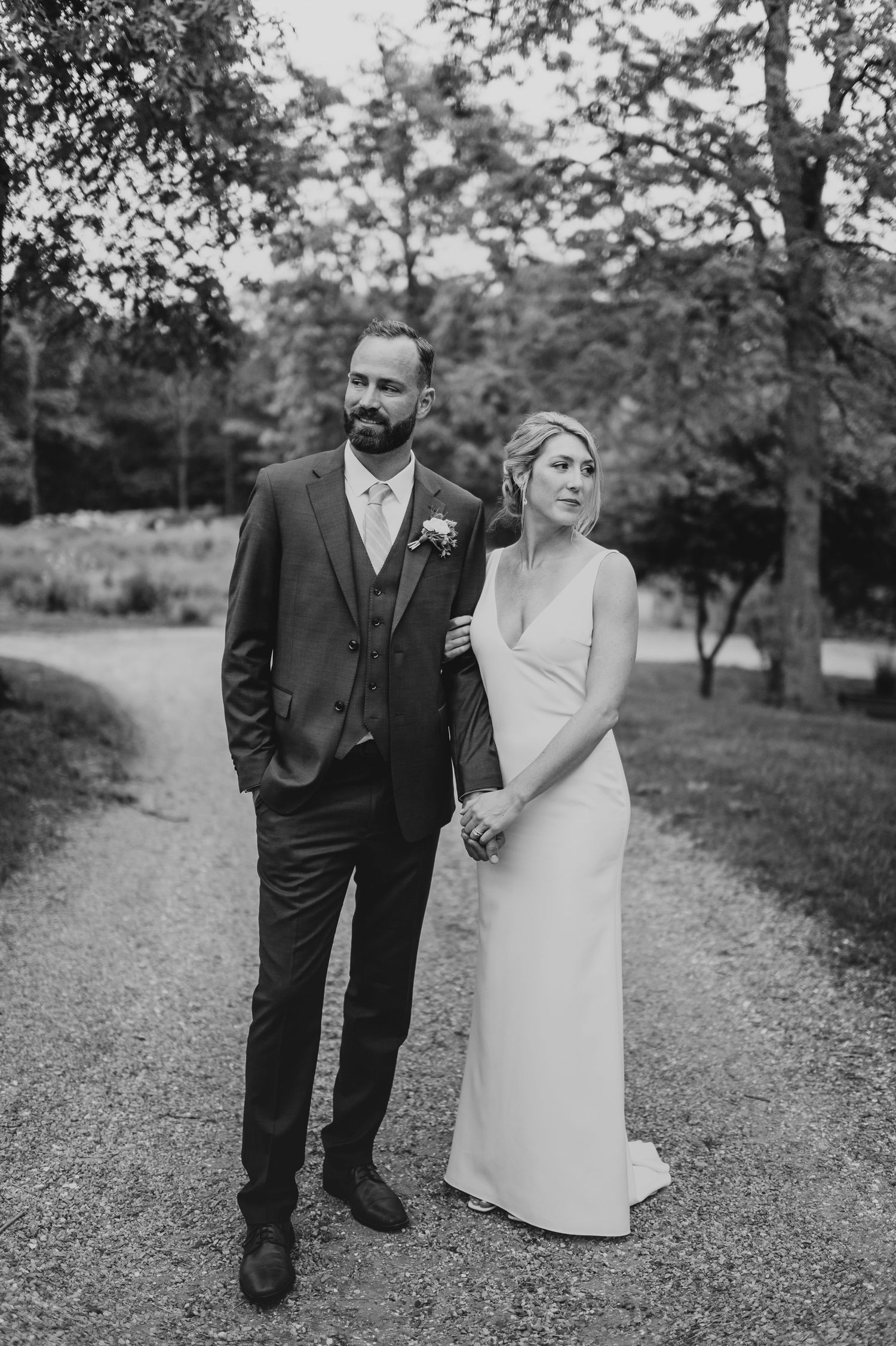 A black and white portrait of newlyweds walking together outdoors.