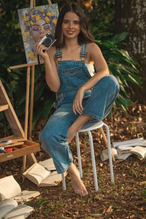 Casual outdoor art session with vintage camera and floral portrait painting on wooden easel.