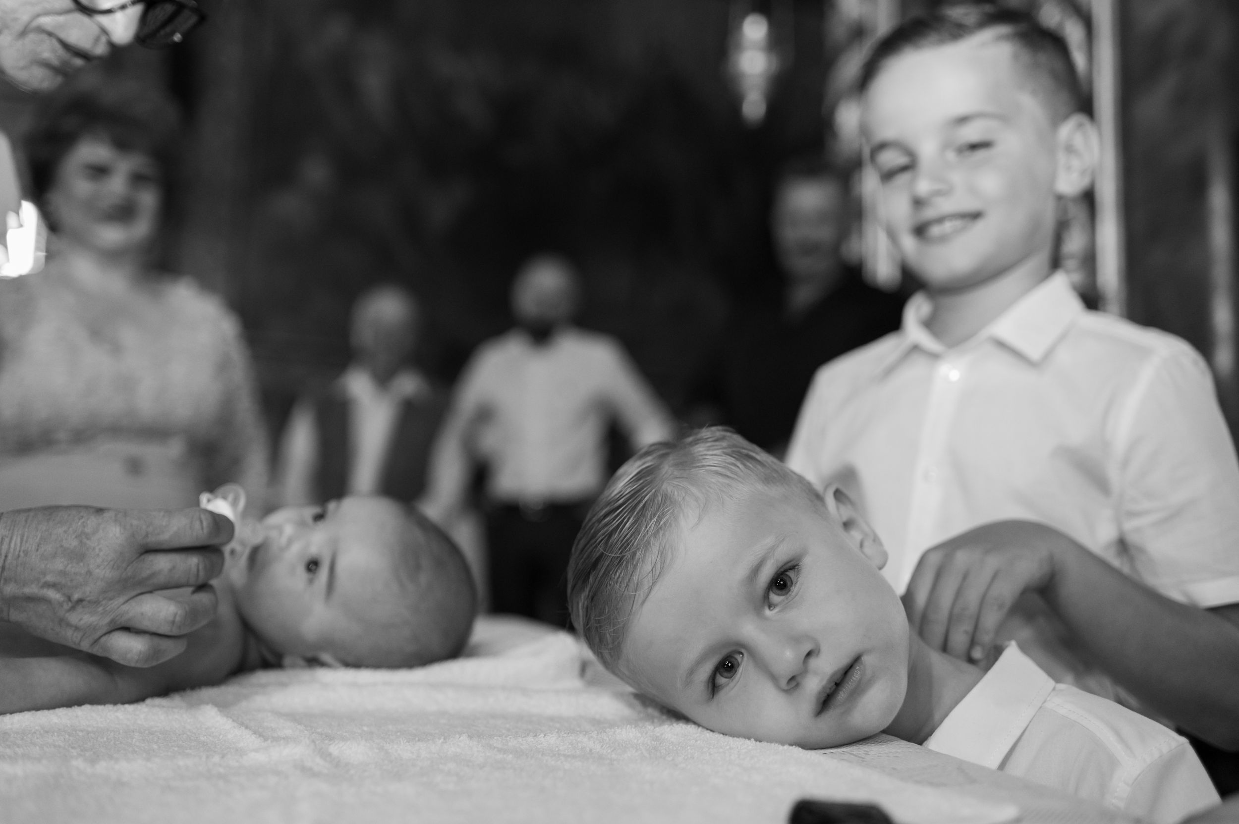 Black and white image of children gathered around a table during a religious ceremony.