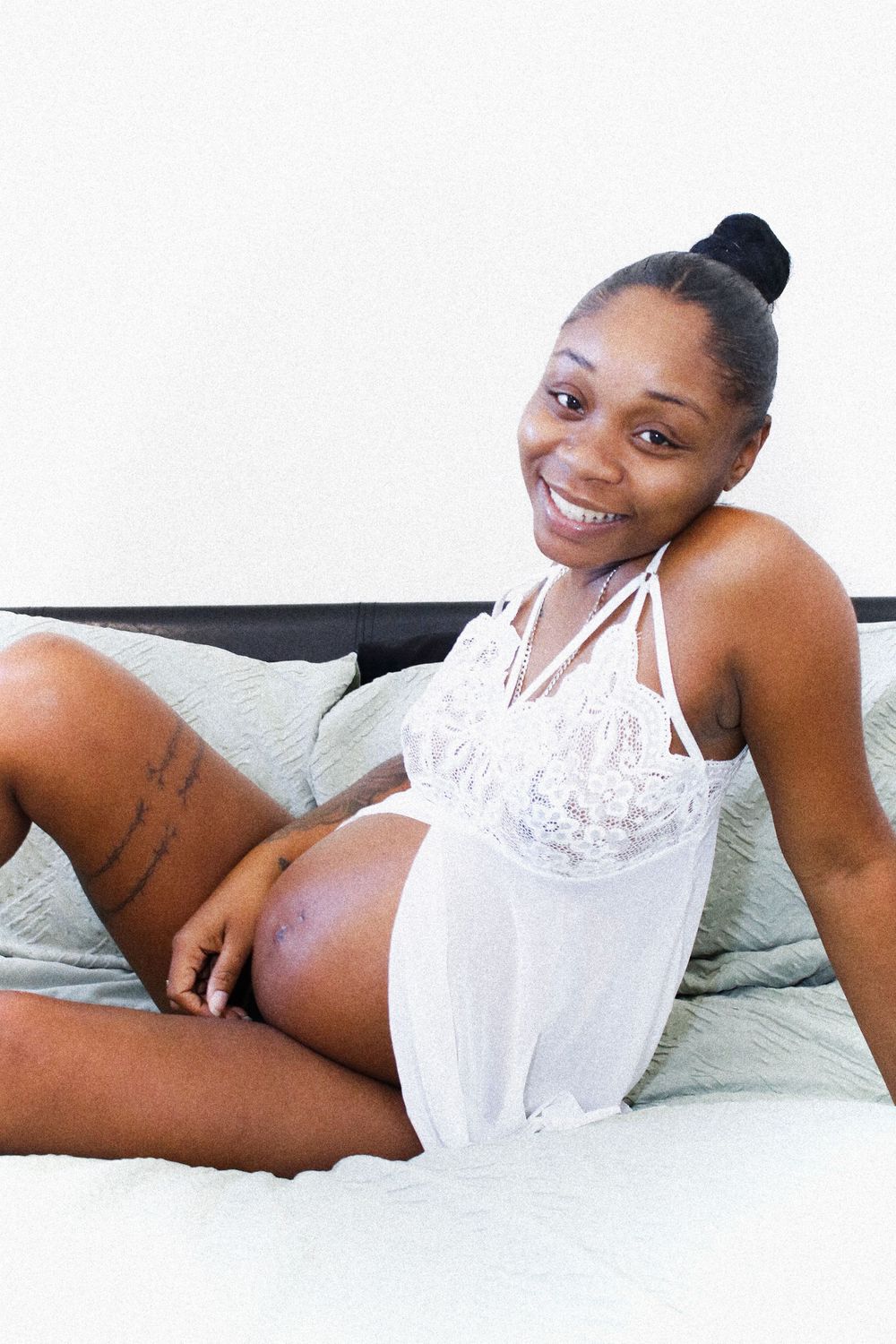 Person wearing white lace lingerie lounges comfortably on a couch with soft pillows.