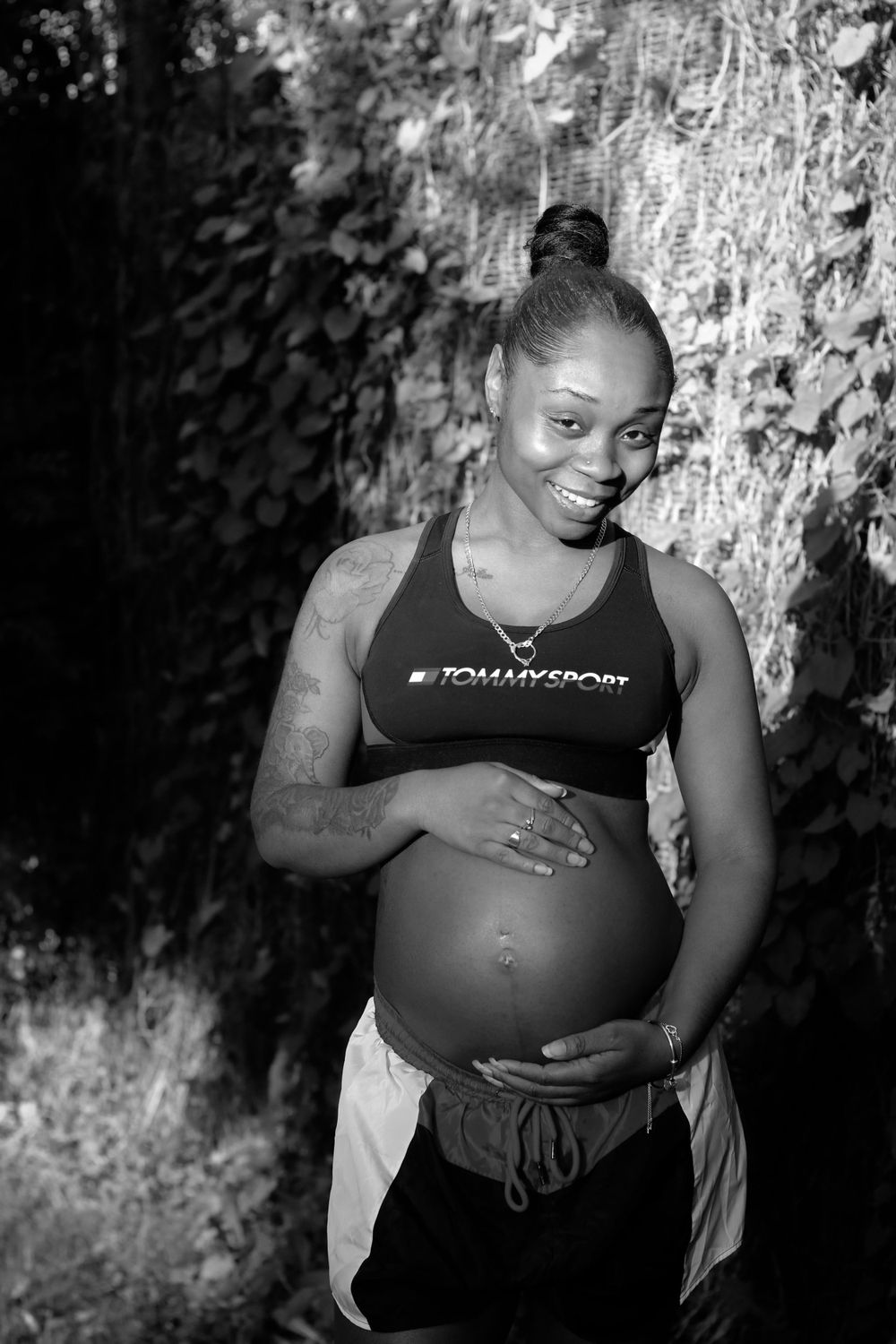Black and white portrait series showing someone in athletic wear posing against a textured background.