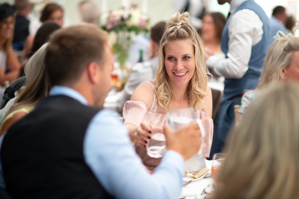 Wedding reception guests socializing and mingling at decorated tables.