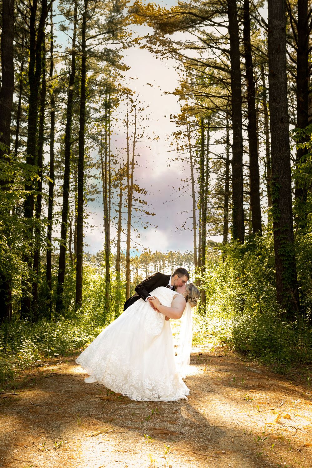 A romantic wedding photo in a sunlit forest path with tall pine trees creating natural framing.
Janesville, WI
Brodhead, WI