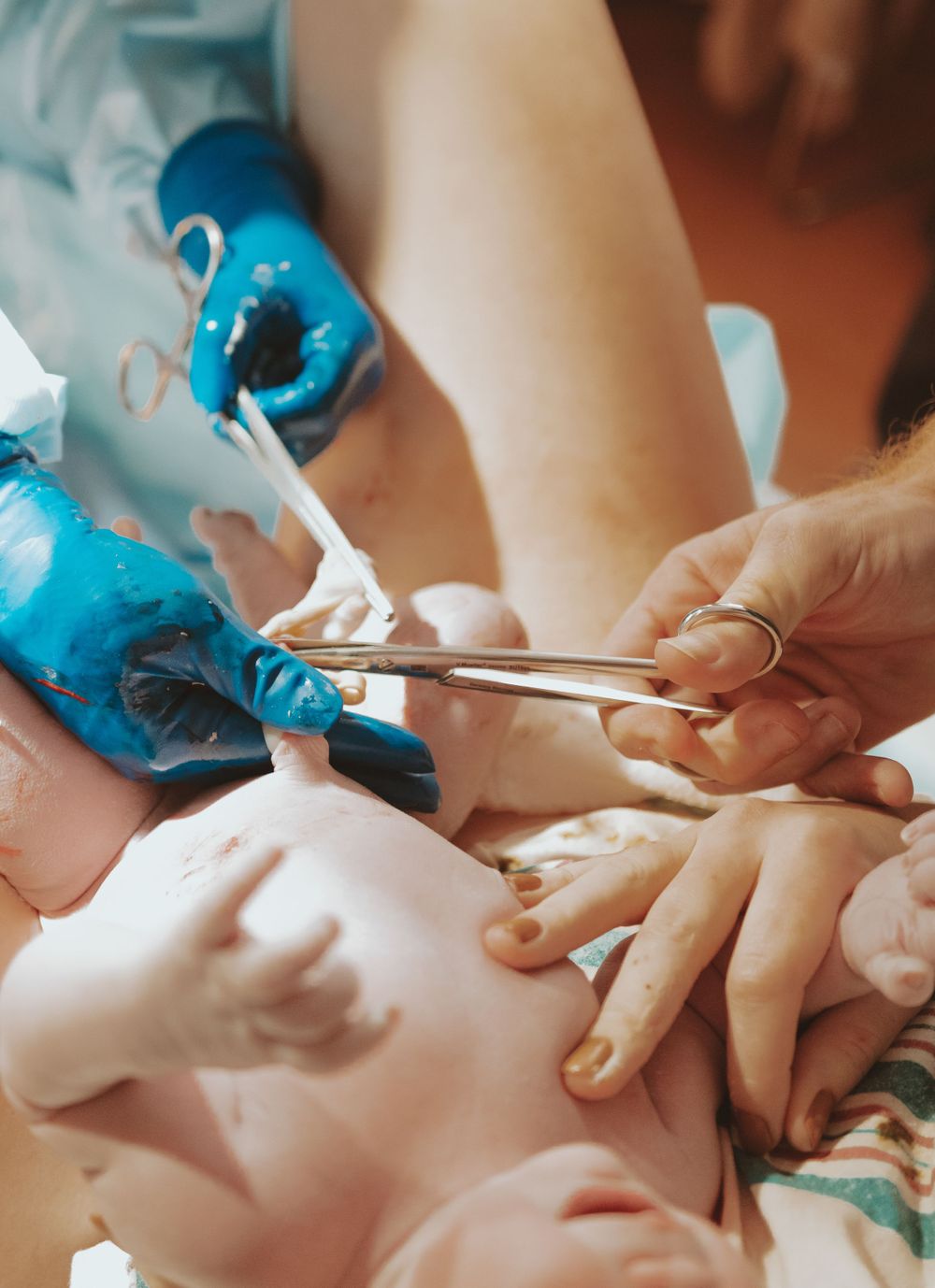Close-up of medical instruments and gloved hands during medical procedure.