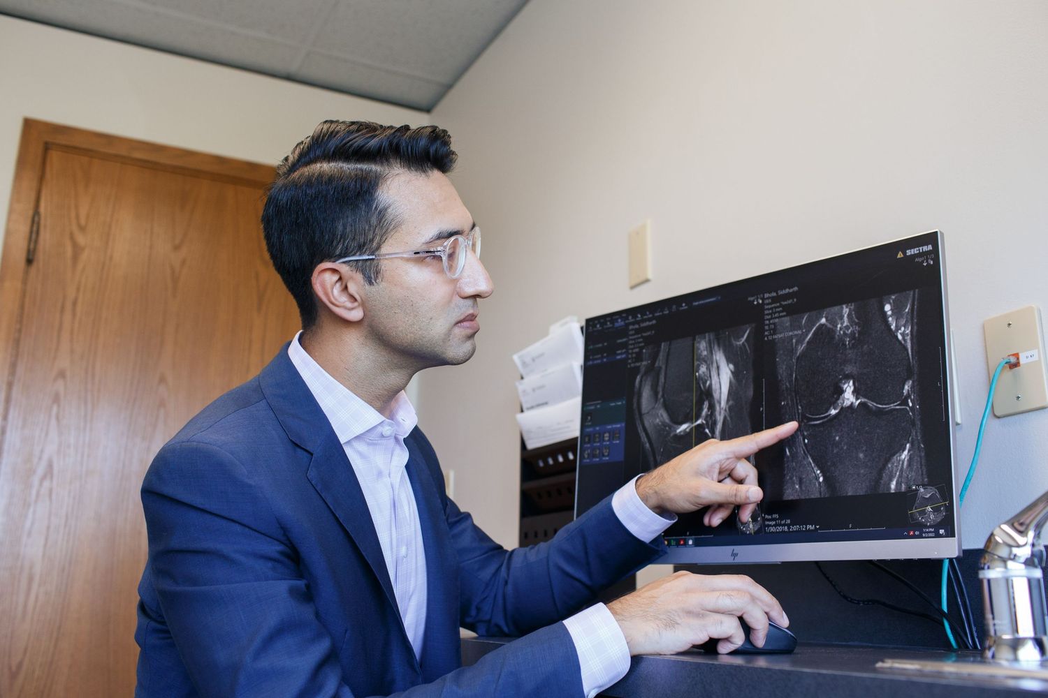Everett marketing photographer: a doctor points to an x-ray at his clinic in Everett