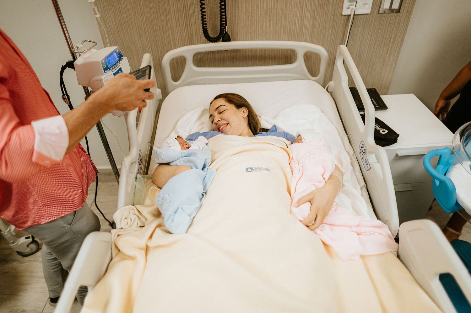 Medical care being provided to patient resting in hospital bed.