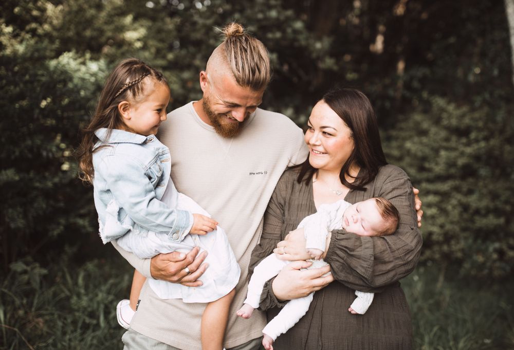 Candid outdoor family portraits showing joyful interactions in natural setting.