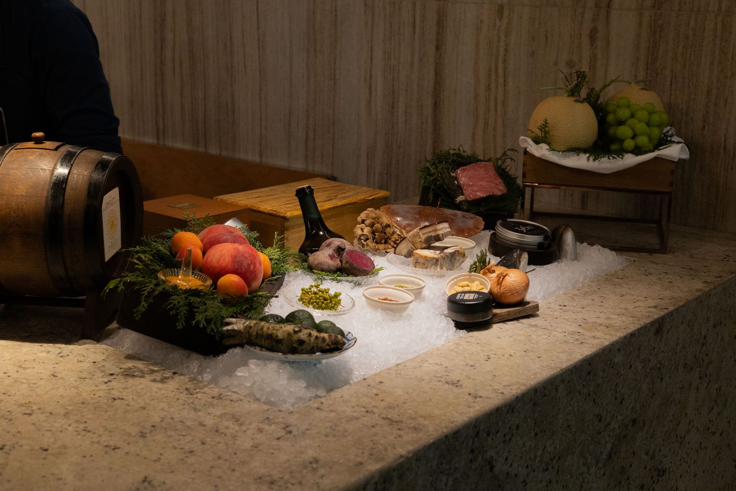 Fresh ingredients and prepared dishes arranged on a rustic stone counter in moody lighting.