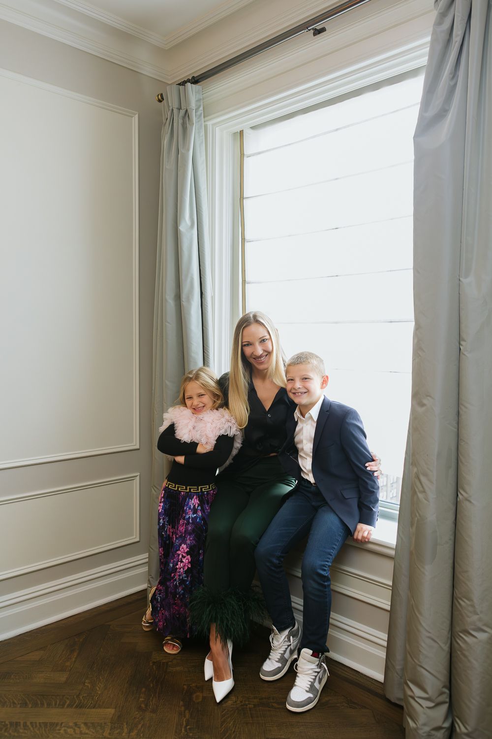 Mom and her two kids by the Plaza Hotel suite window, photo by NYC Family Photographer Paula Ortiz