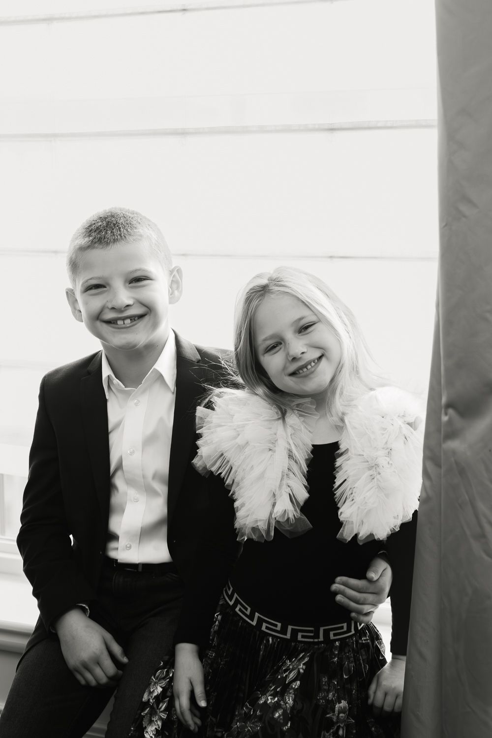 Siblings enjoying the view by the window. Photo by NYC Family Photographer Paula Ortiz