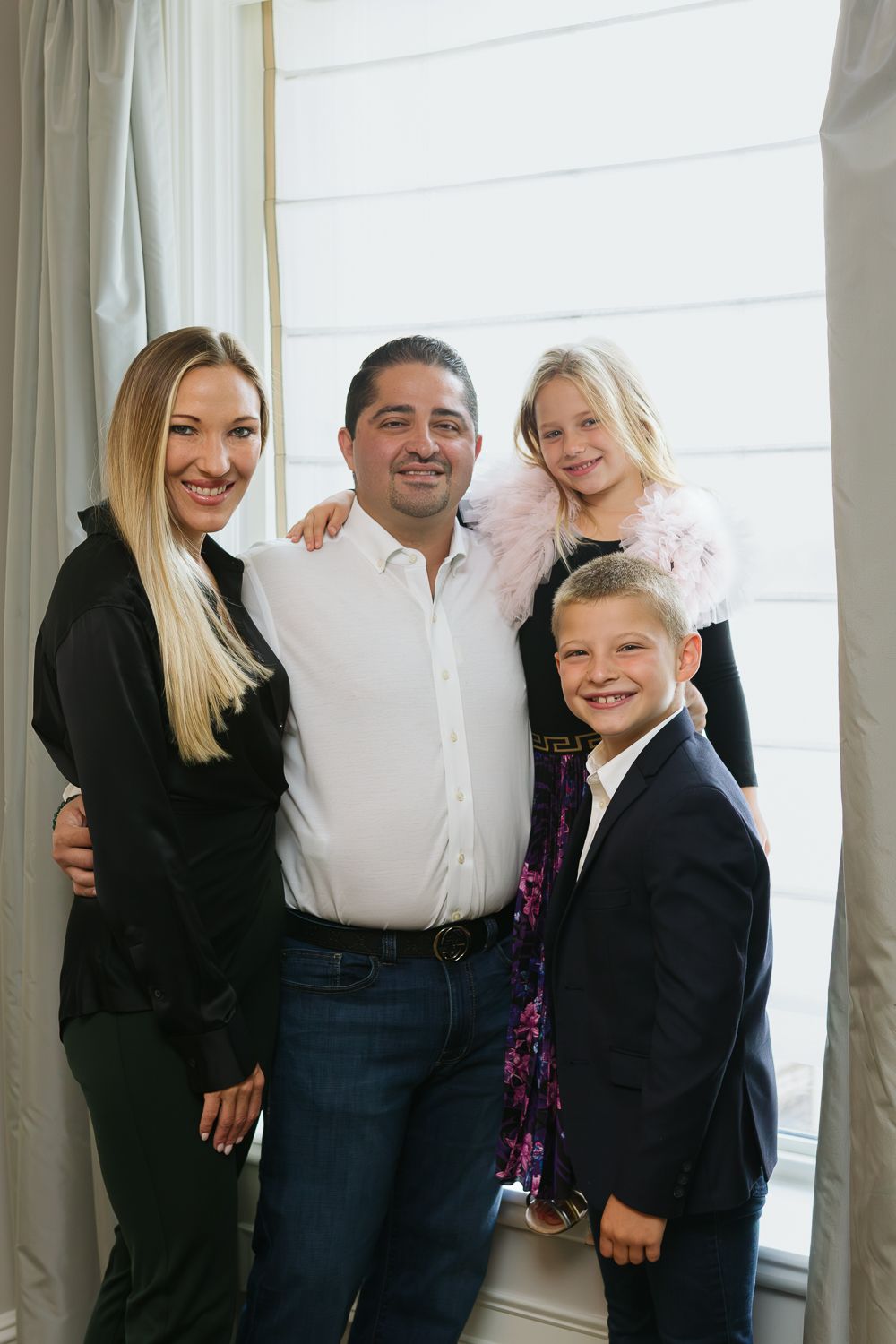 Whole family captured by the suite's window, the Plaza Hotel family photographer Paula Ortiz