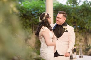 Intimate wedding moment between couple in formal attire sharing a private conversation during outdoor reception.