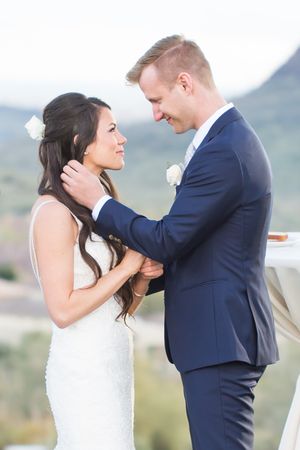 Romantic wedding couple embracing during mountain vista ceremony.