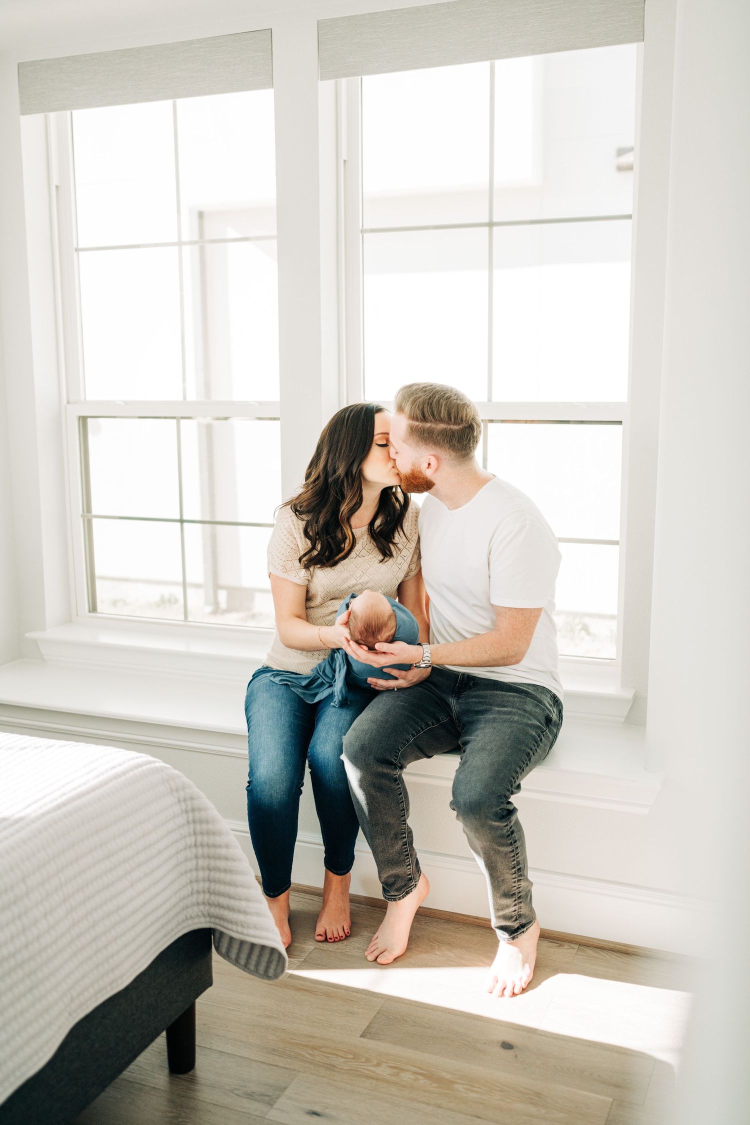 Mom and dad kissing during in home newborn session in Frisco, Texas