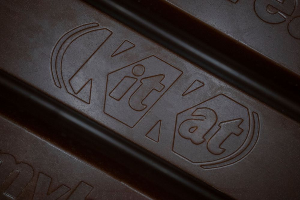 Macro shot of embossed KitKat chocolate bar logo with textured surface detail.
